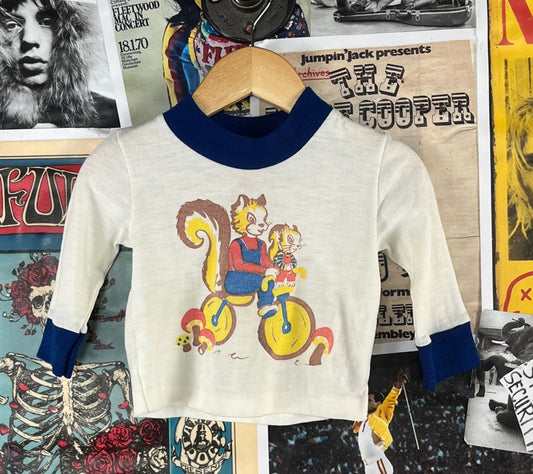 Adorable vintage baby boy girl kids 60s-70s white and blue long sleeve retro bicycle riding squirrels and mushrooms cartoon graphic ringer t-shirt top by Stoneswear. Tagged size 9 months. We estimate it to best fit sizes 6-9 months. Made of 100% acrylic. Has slight yellow hue, but is in otherwise good, pre-owned condition.