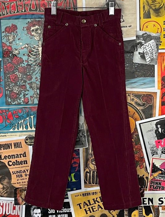 Vintage boys girls kids 1970s burgundy red bootcut corduroy pants by Charlies. Made in the USA. Features a zip fly and buttons at the waist. There is no tag size. We estimate it to fit kids size 8 slim, ages 7-8.
