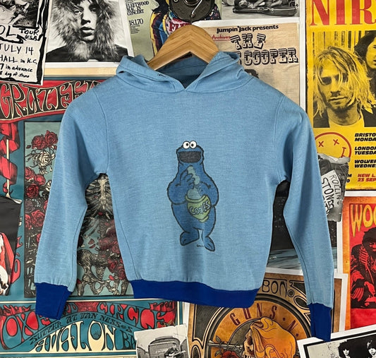 Awesome vintage kids retro 80s two tone blue long sleeve Sesame Street Cookie Monster Muppets Inc cartoon graphic pullover sweatshirt top by JCPenney. Has minor flaws through out and is missing original drawstring. Made of 100% acrilan acrylic. Tagged kids size 6/7. We estimate it to fit kids size 6, ages 5-6.