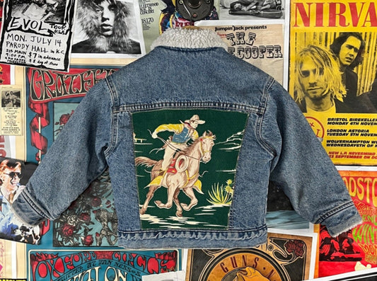 Awesome vintage kids retro 90s blue denim orange tab Little Levi's sherpa jean jacket with custom retro 50s style Western cowboy horse patch appliqué on back. The back patch is a vintage piece of fabric. Made in the USA of 100% cotton. Tagged a kids size 7 which we estimate to fit ages 6-7. Has some light dirt wear discoloration here and there through out, but is in otherwise good pre-owned condition.